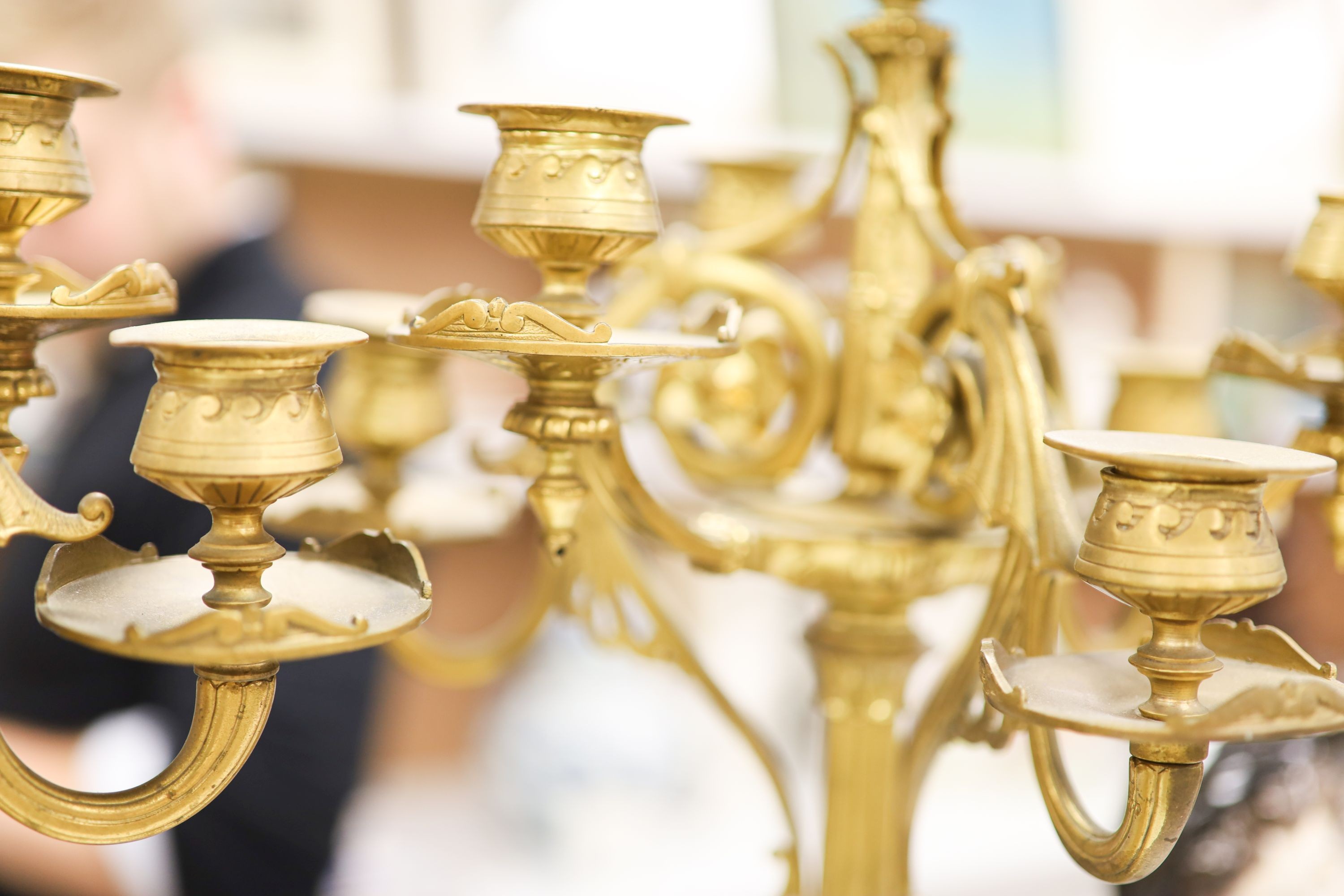A pair of Louis XVI style four branch, five light gilt brass candelabra, with vase shaped stem, on shaped alabaster plinths 76cm